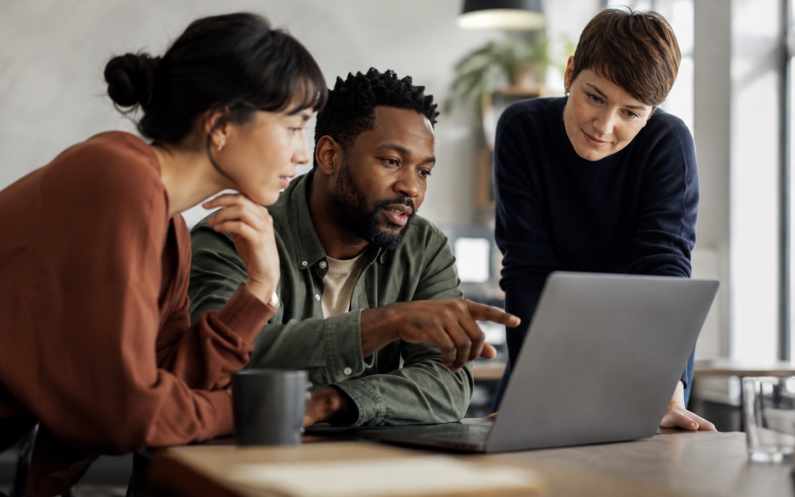 A small group building together around one laptop